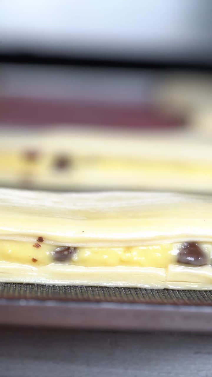 dough being folded and sealed with filling inside, showing texture and details during food preparation. close up shot, insert shot