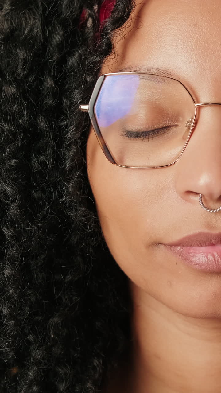 Close-up Portrait of a Smiling Woman with Glasses and Curly Hair