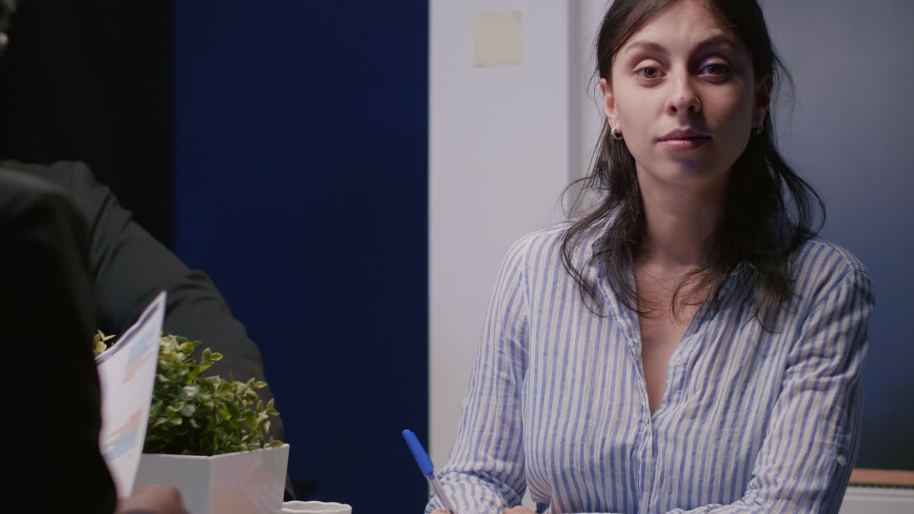 Close up of workmates analyzing blueprints plan and building model on table
