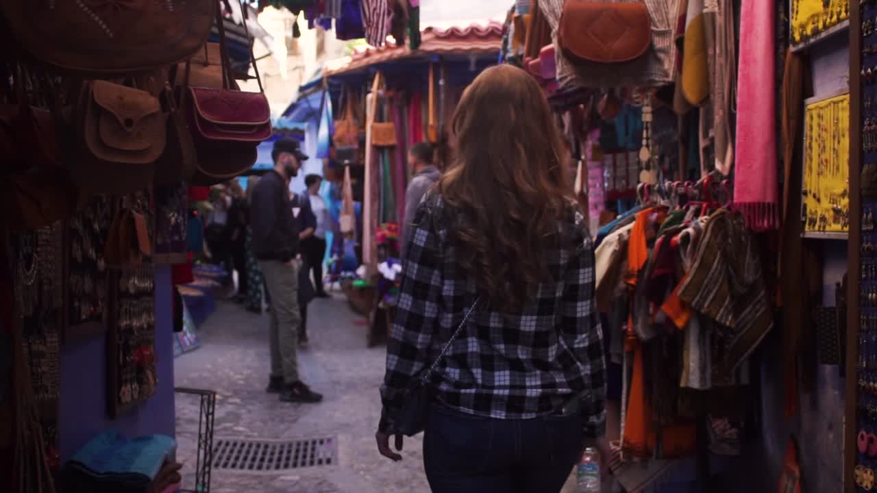 A woman walking in a street inside old medina of Chefchaouen city, Morocco