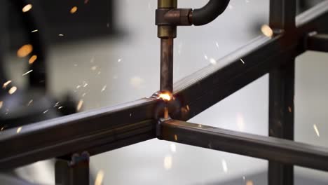 welding process highlighting a metal frame connection with sparks and intense heat generated by the welding torch in an industrial setting