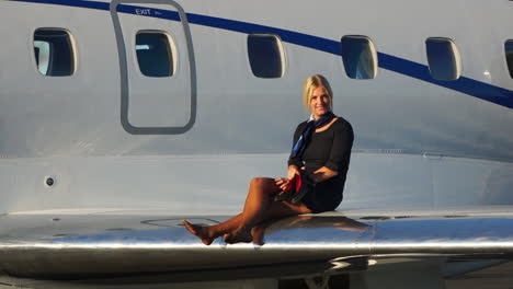 a playful flight attendant walks on the wing of an aircraft