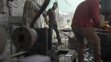 ironworkers forging metal in a manufacturing workshop in pakistan