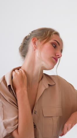 young blonde woman feels tired and massages sore neck with hand working on small laptop at white table in modern home office slow motion