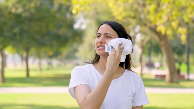 mujer india limpiando el sudor después de una sesión de carrera en un parque por la mañana