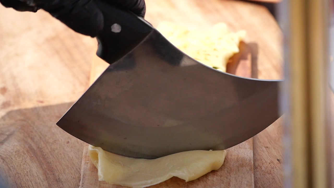 Cutting Savory Crepes Filled with Feta Cheese and Vegetables