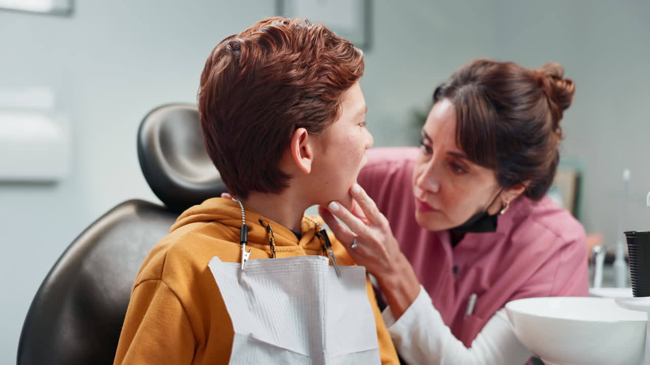 치과 의사가 치과 사무실 에서 어린 소년 의 치아 를 검사 하고 있다