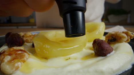 chef preparing a pear and yogurt dessert with honey and nuts