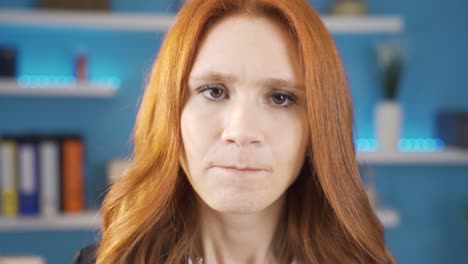 young woman getting angry looking at camera in office.