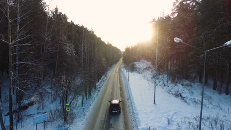 snowy forest road with car