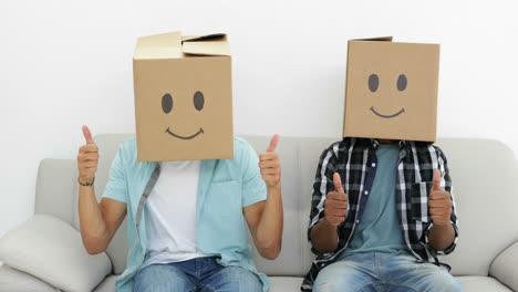 silly employees with boxes on their heads giving thumbs up