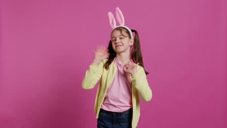 adorable cute child putting bunny ears and waving at camera,