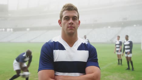 rugby player standing with arms crossed in stadium 4k