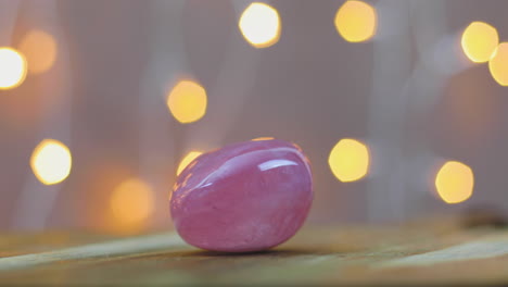 love healing rose quartz gemstone on wooden table with lights