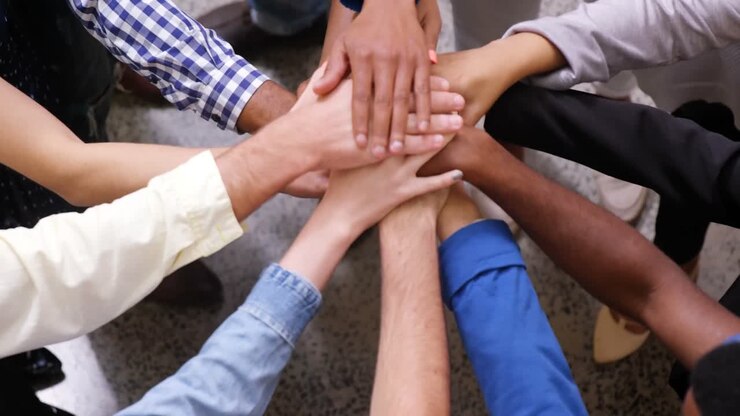 Mani di un team aziendale che uniscono le mani a pila