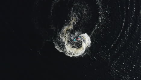 Aerial-top-down-view-of-a-fast-water-scooter-jet-ski-going-around-in-circles-and-making-beautiful-white-foamy-waves-in-Sweden