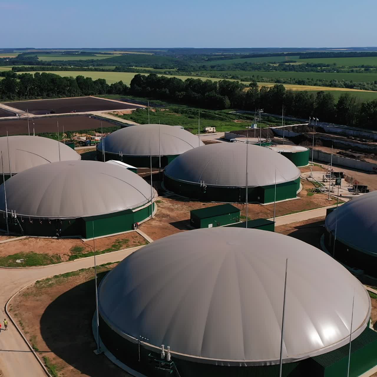 Modern agricultural complex in the farmlands. Biogas plant for the production of green energy. Futuristic constructions against the beautiful nature landscape