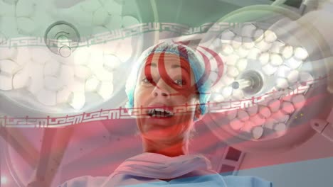 Animation-of-flag-of-iran-waving-over-female-surgeon-in-operating-theatre