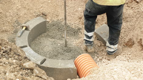 Labourer-Compacts-The-Cement-Near-The-Concrete-Bricks-At-Construction-Area-In-Leiria,-Portugal