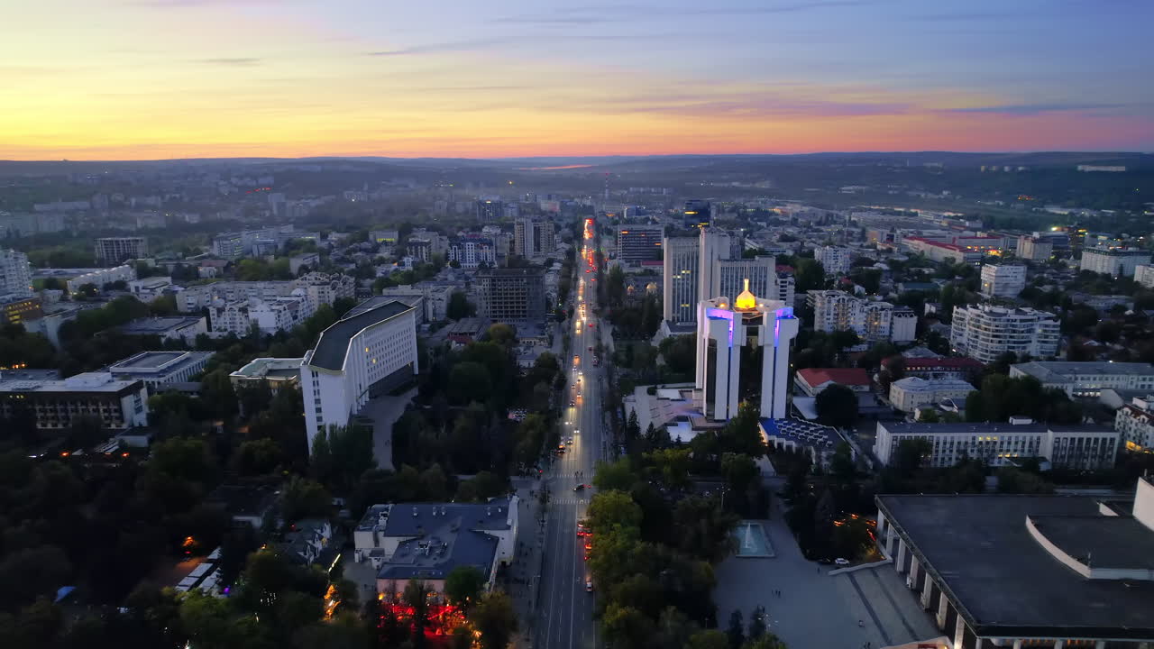 Aerial drone view of Chisinau at evening, Moldova. View of city centre with presidency and parliament, multiple buildings, roads, illumination