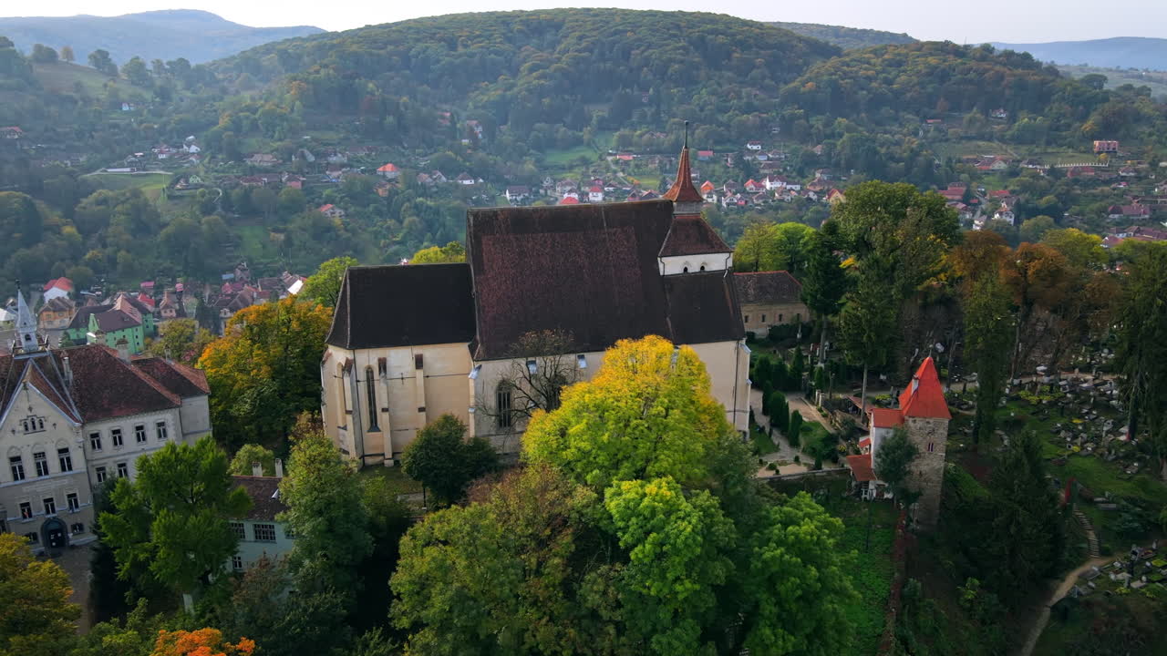 Aerial drone view of the Historic Centre of Sighisoara, Romania. Old buildings, Church on the Hill, surrounded by greenery