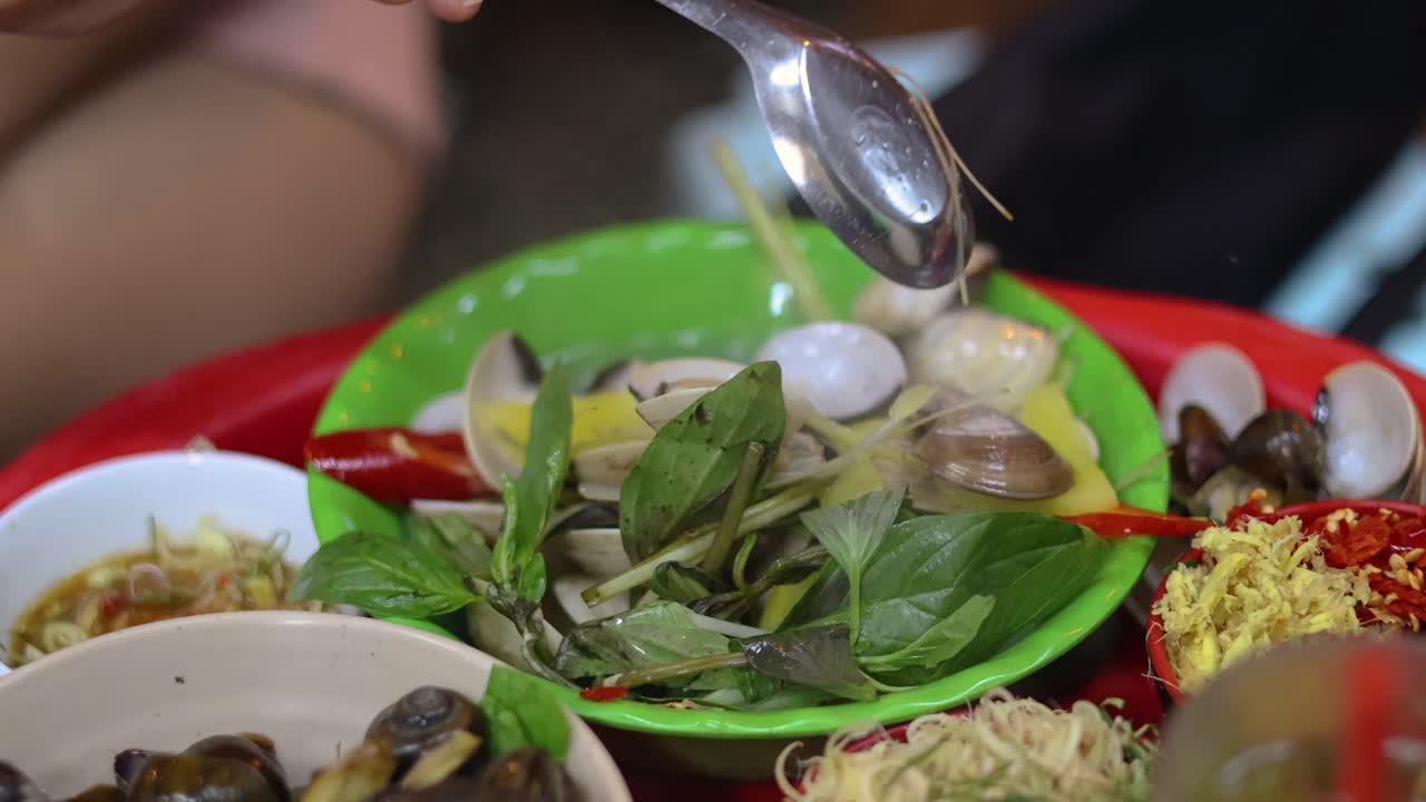 Scooping shellfish and vegetables with a spoon