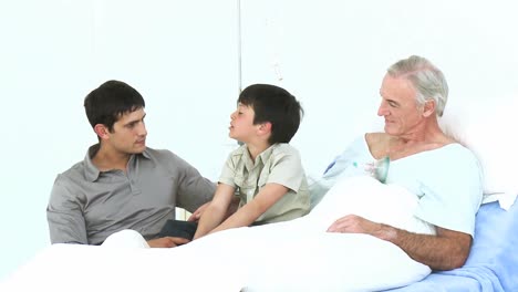 dad and son visiting a grandfather recovering in hospital