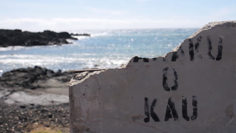 broken concrete block sits on shore of beach in hawaii