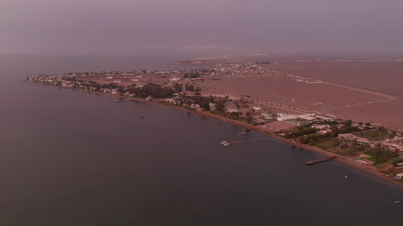 페루의 서해안을 따라 촬영된 공중 돌리는 해안 휴양지와 주택을 보여주며 차분하고 화창한 오후에 촬영되었습니다.
