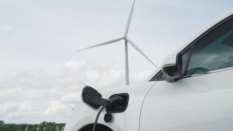 progressive combination of ev car, charging station and wind turbine.