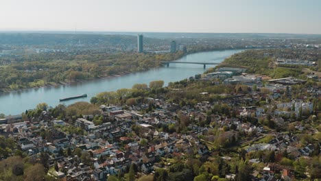 Drone---Toma-Panorámica-Aérea-De-Bonn-Con-El-Puente-Konrad-Adenauer,-El-Río-Rin-Con-Un-Barco,-El-Gran-Hotel-Kameha-Y-La-Torre-De-Correos-25p