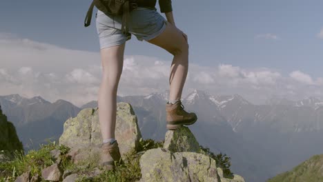 Joven-Excursionista-Mirando-Desde-La-Cima-De-Una-Alta-Montaña-Sintiéndose-Alta-Y-Empoderada-Sintiéndose-En-La-Cima-Del-Mundo-E-Imparable