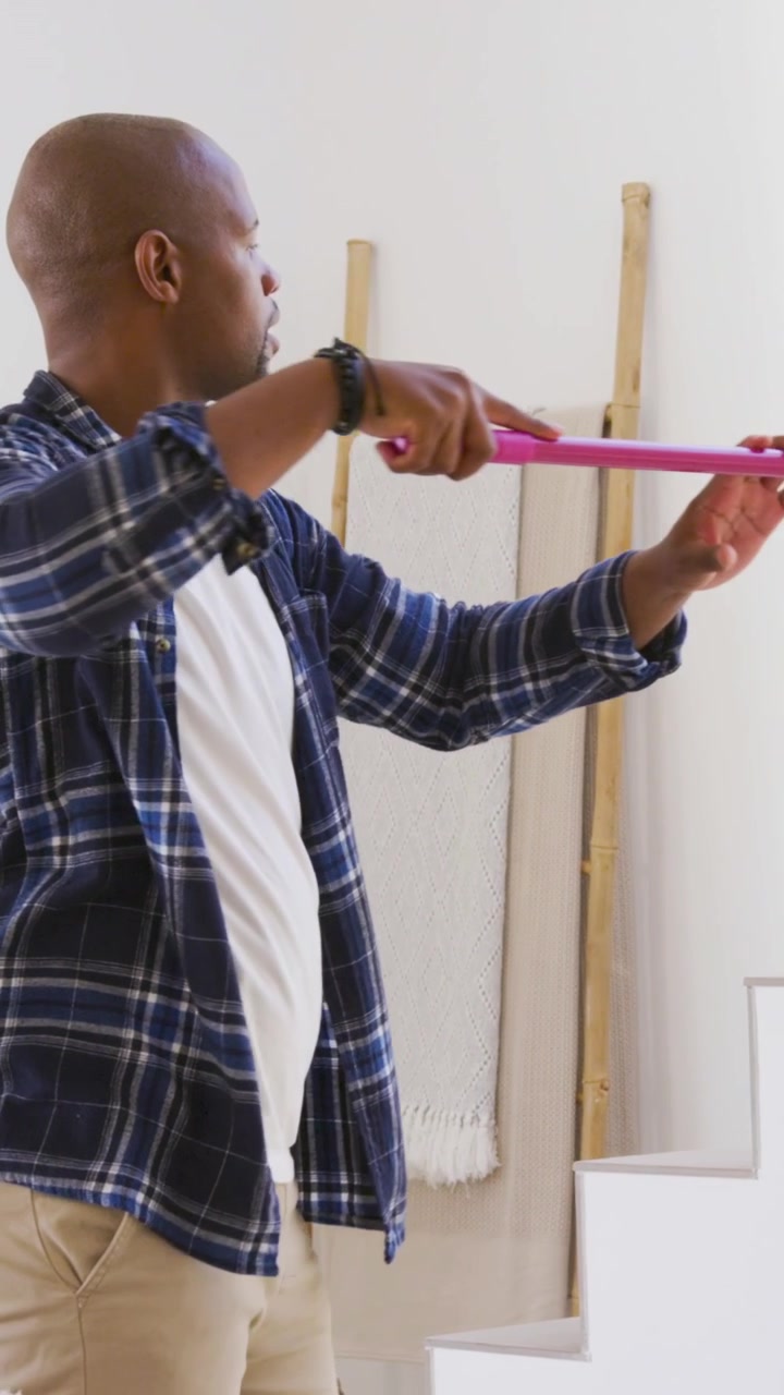 Vertical video: Using pink level plaid-clad man checking stair line marking silver can for shelf