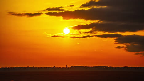 Timelapse-of-the-view-of-the-round-sun-at-dusk-with-a-blushing-orange-sky