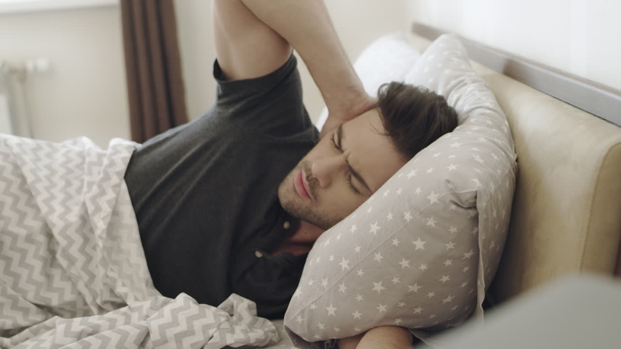 잠자는 남자가 알람 시계 소리를 싫어한다