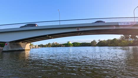 boat passes under bridge on sunny day