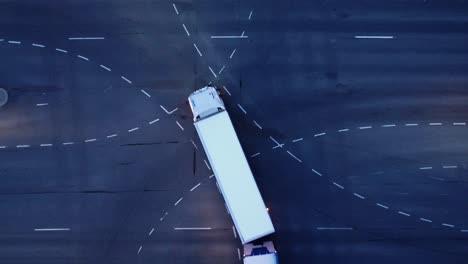 pattern of painted lines in multi-lane intersection at dusk, vehicles