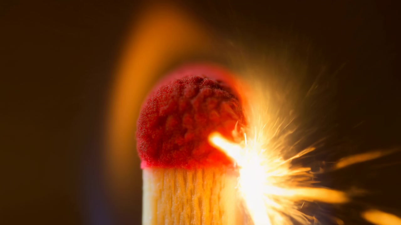 Closeup Red Match Head Igniting, Studio Macro Capture Showing Spark Eruption And Flame Enveloping Tip,