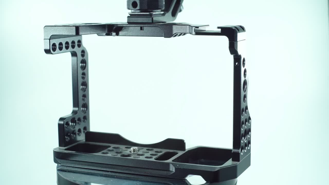 un primer plano de una jaula de cámara de metal negro, equipo de producción de video, en un soporte giratorio 360, luz de estudio, cámara lenta, 4k