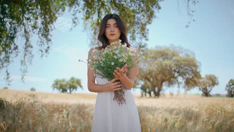 serene lady admiring bouquet at spikelet meadow zoom on. woman enjoying flowers