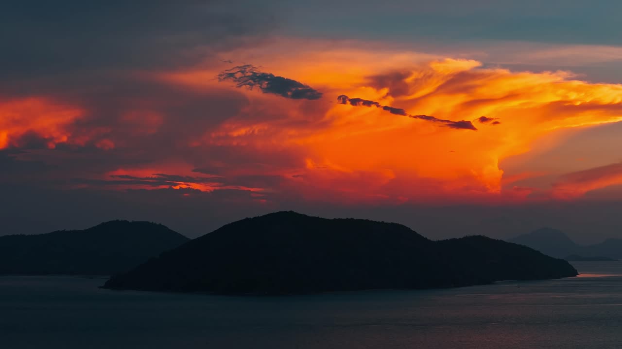 Dramatische orange Wolke bei Sonnenuntergang über Inseln.