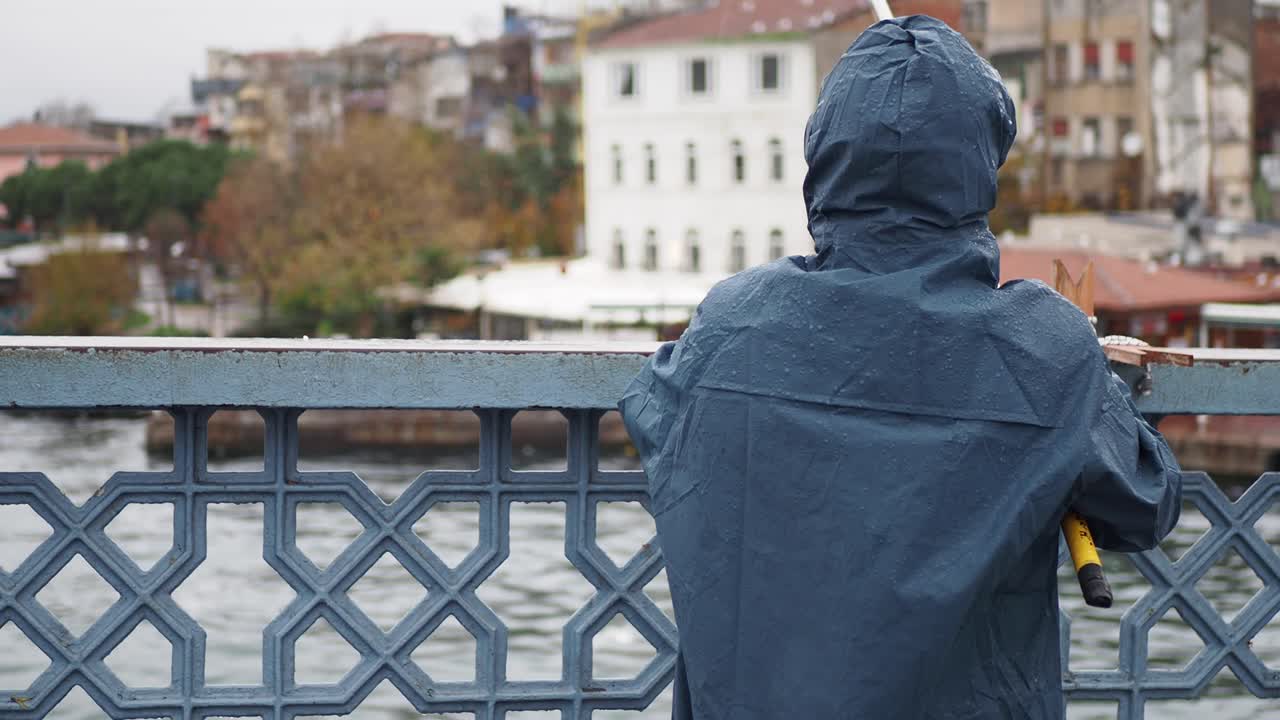 hombre pescando desde un puente en una ciudad
