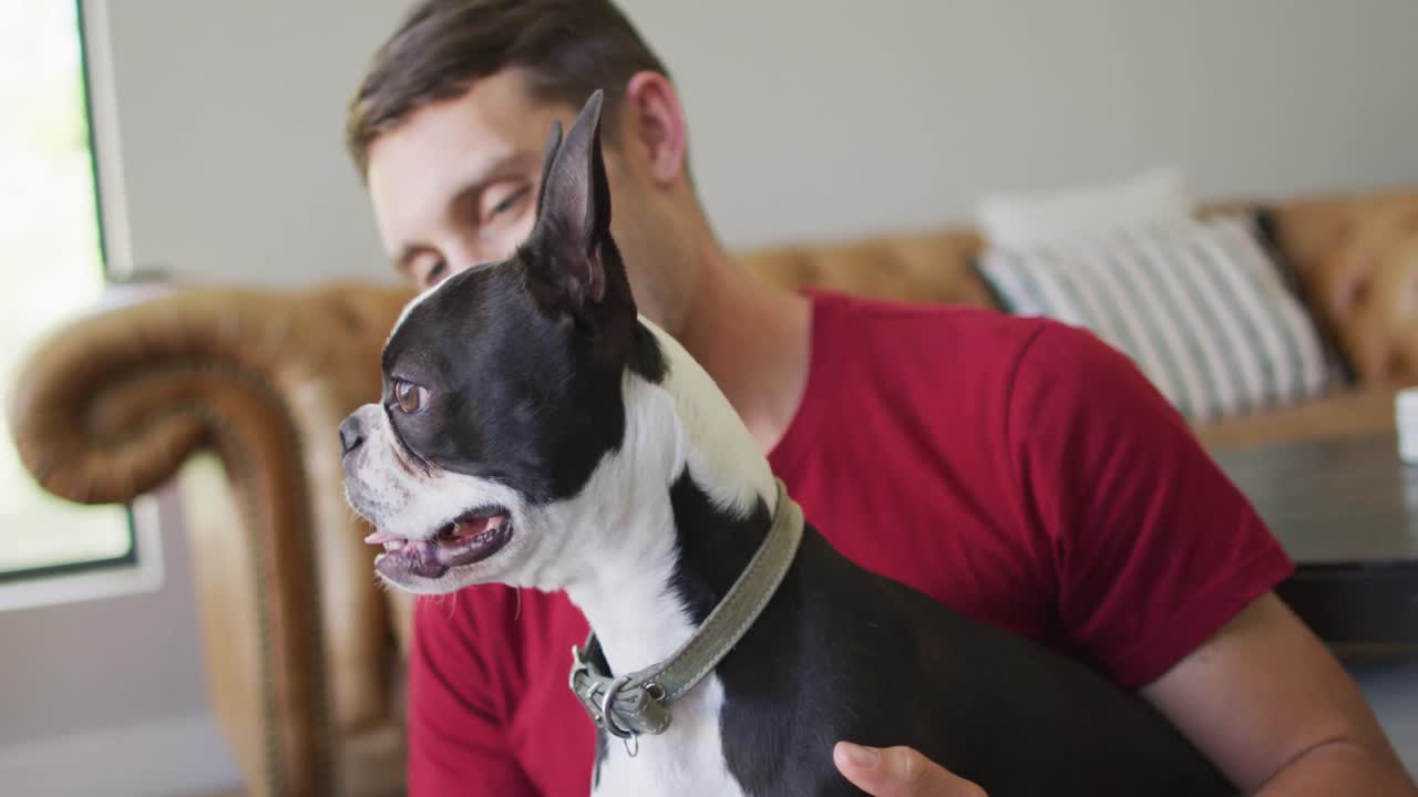 Caucasian man is playing with his dog at home