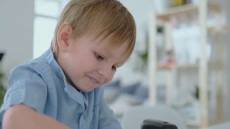 The-boy-sitting-at-the-table-in-the-living-room-writes-a-letter-to-his-father-and-draws-a-picture-of-the-family-with-a-pencil