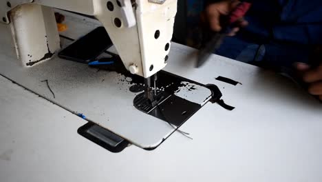 tailor cutting excess cloth with scissors after sewing, close up