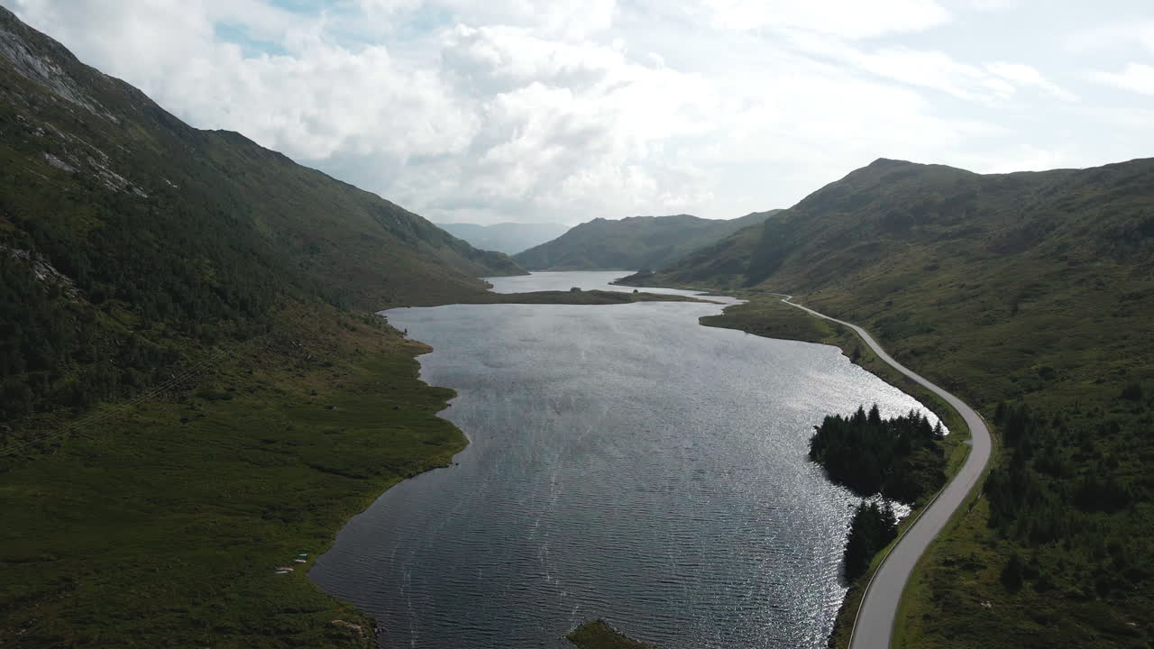 Drone flying in a valley over a lake on a sunny summer day in norway