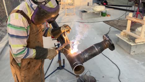 Close-up-shot-of-a-welder-turning-the-pipe-as-he-goes