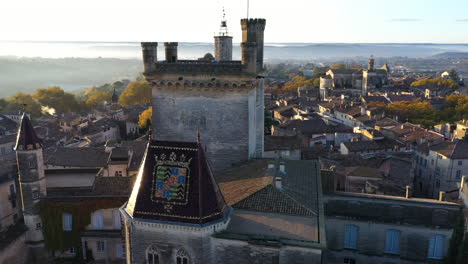 Luftaufnahme-Des-Herzogtums-Uzès-Oder-Des-Herzogsschlosses-Bei-Sonnenaufgang,-Frankreich-Gard-Emblem