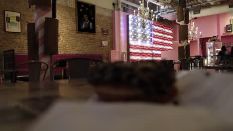 close up of a doughnut at voodoo doughnut shop in austin, texas with lighted american flag in the background with stable video