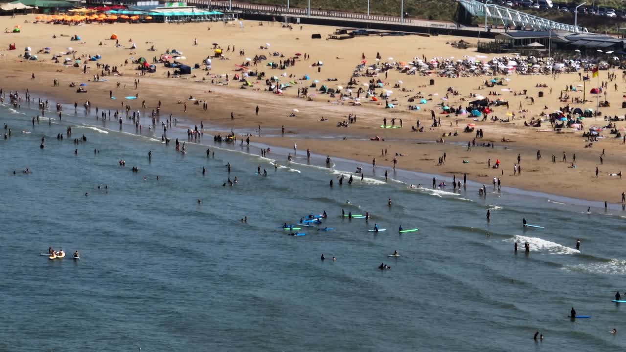 많은 사람 들 이 하루 를 즐기고 있는 해변 장면